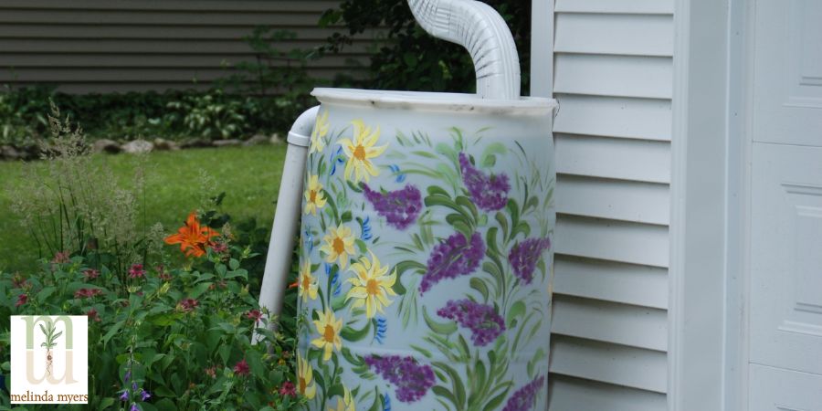 painted rain barrel against a house