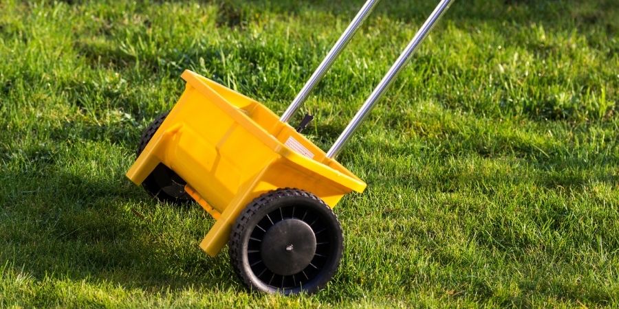 yellow drop spreader on lawn