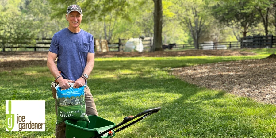 joe gardener holding fertilizer in a lawn