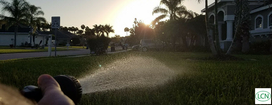 Watering the lawn with hand sprinkler