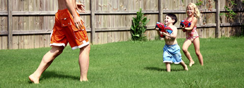 Children playing on grass. Children playing on green, healthy grass in the summer.